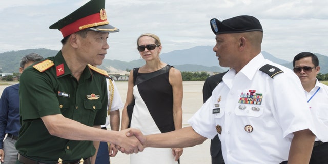 U.S. Army Lt. Col. Romel Pajimula, Defense POW/MIA Accounting Agency (DPAA) detachment commander, right, greets Senior Col. Nguyen Huu Luong, Vietnamese Office for Seeking Missing Persons (VNOSMP) Ministry of Defense deputy director, prior to witnessing a repatriation ceremony, Da Nang, Socialist Republic of Vietnam, July 8, 2018.