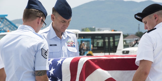 U.S. service members assigned to the Defense POW/MIA Accounting Agency (DPAA), drape a transfer case with the American flag during a repatriation ceremony, Da Nang, Socialist Republic of Vietnam, July 8, 2018.