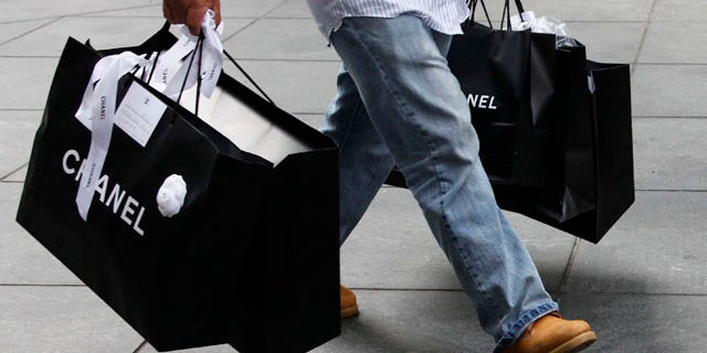 Oct. 25: A man carries Chanel shopping bags in New York. Retail sales increased in October by the largest amount since March, easing worries over the economic recovery.