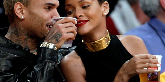 Chris Brown, left, and Rihanna attend an NBA basketball on Dec. 25, 2012.