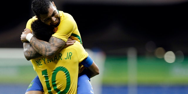 Brazil's Gabriel Barbosa celebrates with teammate Neymar after scoring his team's first goal during a group A match of the men' s Olympic football tournament between Brazil and Denmark in Salvador, Brazil, Wednesday Aug. 10, 2016.(AP Photo/Leo Correa)