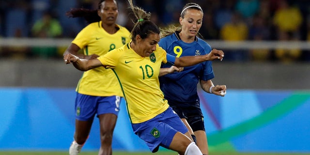 Brazil's Marta, center, dribbles past Sweden's Kosovare Asllani during a group E match of the women's Olympic football tournament between Sweden and Brazil at the Rio Olympic Stadium in Rio De Janeiro, Brazil, Saturday, Aug. 6, 2016. (AP Photo/Leo Correa)
