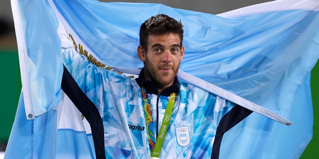 Silver medalist Juan Martin del Potro, of Argentina, drapes a flag over his shoulders as he thanks the crowd after the men's singles gold medal match at the 2016 Summer Olympics in Rio de Janeiro, Brazil, Sunday, Aug. 14, 2016. (AP Photo/Charles Krupa)