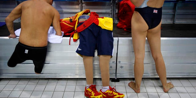 FILE - In this Aug. 31, 2012 file photo, Spain's Xabi Torres jumps next to his prosthesis as he leaves the swimming pool after training ahead of the competition at the 2012 Paralympics Olympics in London.  The countdown clock for the Paralympic Games in Rio reaches 100 days on Monday with about 4,300 athletes participating, far fewer than the 10,500 in the Olympics. The Paralympic Games open Sept. 7.(AP Photo/Emilio Morenatti, File)