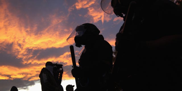 DENVER, CO - OCTOBER 29: Riot police face off with demonstrators at the "Occupy Denver" camp on October 29, 2011 in Denver, Colorado. Following a march by protesters, police moved in on their encampment to tear down recently erected tents. They arrested numerous protesters, pepper-sprayed others and others reportedly fired rubber bullets at the crowd during the confrontation. (Photo by John Moore/Getty Images)