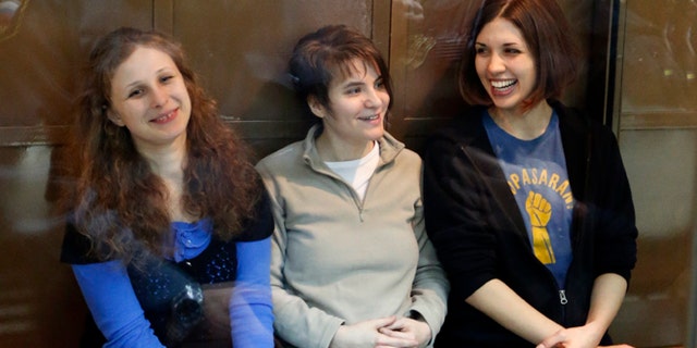 In this Oct. 1, 2012 file photo, feminist punk group Pussy Riot members, from left, Maria Alekhina, Yekaterina Samutsevich and Nadezhda Tolokonnikova sit in a glass cage at a court room in Moscow, Russia. Alekhina went on hunger strike May 22, 2013, in protest at not being allowed to attend her own parole hearing in Perm province.