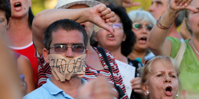 Aug. 21, 2012: Protesters shout anti presidential slogans downtown Bucharest, Romania.