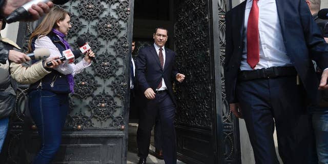 Romanian Premier Victor Ponta, center, is greeted by reporters as he exits the High Court of Cassation and Justice, in Bucharest, Romania, Wednesday, Mar. 11, 2015. Romania’s prime minister has appeared before the High Court of Cassation and Justice to give evidence in a probe into allegations of fraud during a referendum to impeach the former president. (AP Photo/Octav Ganea, Mediafax) ROMANIA OUT