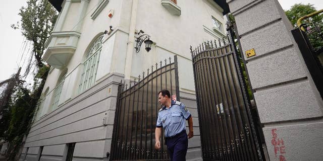 A police officer exits the gate of Romanian Prince Paul's house, in Bucharest, Romania, Thursday, Sept. 10, 2015. The prince's lawyer says his client, who is a grandson to Romania's King Carol II and a nephew to former King Michael, will pay 4.7 million pounds ($7.28 million) to a British Royalty Magazine editor, Marco Houston, following a court decision. (Octav Ganea, Mediafax via AP) ROMANIA OUT