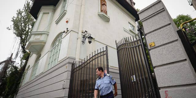 A police officer exits the gate of Romanian Prince Paul's house, in Bucharest, Romania, Thursday, Sept. 10, 2015. The prince's lawyer says his client, who is a grandson to Romania's King Carol II and a nephew to former King Michael, will pay 4.7 million pounds ($7.28 million) to a British Royalty Magazine editor, Marco Houston, following a court decision. (Octav Ganea, Mediafax via AP) ROMANIA OUT