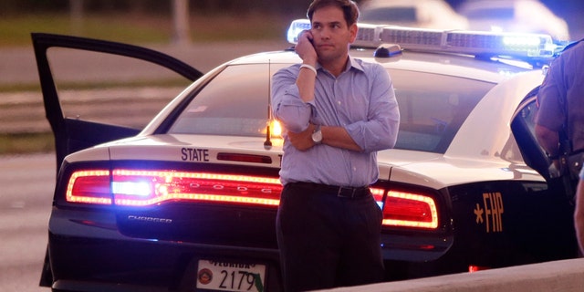 Sen. Marco Rubio, R-Fla., who is traveling with Republican presidential candidate and former Massachusetts Gov. Mitt Romney, uses a phone as he stands alongside Interstate 4 in Lakewood Crest, Fla., Saturday, Oct. 27, 2012 after the motorcade was stopped. The 12-year-old daughter of Sen. Rubio had been airlifted to a hospital after a Saturday motor vehicle accident. A Rubio spokesman reports that the girl is in stable condition. (AP Photo/Charles Dharapak)