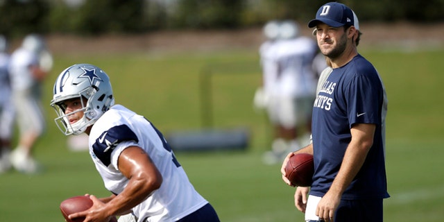 FILE - In this Oct. 26, 2016, file photo, Dallas Cowboys quarterback Tony Romo looks on as fellow quarterback Dak Prescott runs a drill during football practice at the team's practice facility in Frisco, Texas. Romo is running the scout team in practice even though Dallas' starting quarterback the past 10 years looks ready to return from a back injury. (AP Photo/LM Otero, File)