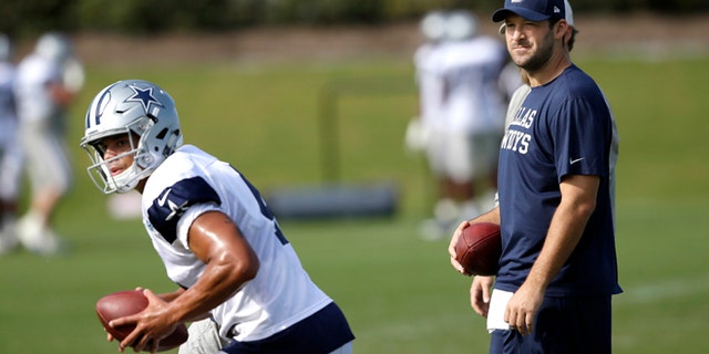 FILE - In this Oct. 26, 2016, file photo, Dallas Cowboys quarterback Tony Romo looks on as fellow quarterback Dak Prescott runs a drill during football practice at the team's practice facility in Frisco, Texas. Romo is running the scout team in practice even though Dallas' starting quarterback the past 10 years looks ready to return from a back injury. (AP Photo/LM Otero, File)