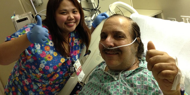 Ron Jeremy poses with one of his nurses while in the hospital.