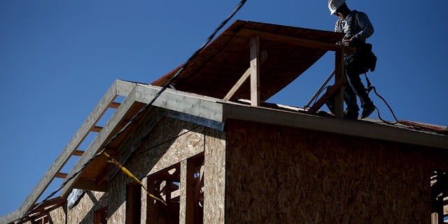 PETALUMA, CA - JANUARY 21: A worker walks on a roof as he builds a new home on January 21, 2015 in Petaluma, California. According to a Commerce Department report, construction of new homes increased 4.4 percent in December, pushing building of new homes to the highest level in nine years. (Photo by Justin Sullivan/Getty Images)