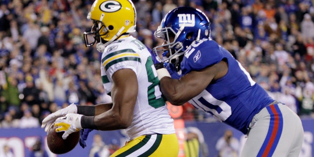 Green Bay Packers' Greg Jennings (85) catches a pass as New York Giants' Prince Amukamara (20) defends during the third quarter of an NFL football game Sunday, Dec. 4, 2011, in East Rutherford, N.J. The play was ruled a touchdown. (AP Photo/Kathy Willens)