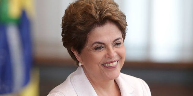 Brazil's suspended President Dilma Rousseff smiles as she arrives to read a letter to the people and to the Senate of Brazil, from Alvorada Palace, in Brasilia, Brazil, Tuesday, Aug. 16, 2016. President Rousseff is proposing to let Brazilians decide if they want to hold new, early presidential elections if lawmakers restore her to power. (AP Photo/Eraldo Peres)