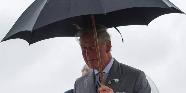Prince Charles arrives in the rain at a Canadian Forces Base airport in Winnipeg, Canada, May 20, 2014 (AP Photo/The Canadian Press, David Lipnowski)