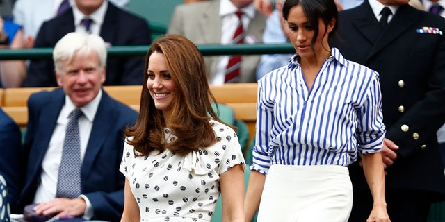 Kate, Duchess of Cambridge, right, and Meghan, Duchess of Sussex take their seats in the Royal Box on Centre Court ahead of the women's singles final.