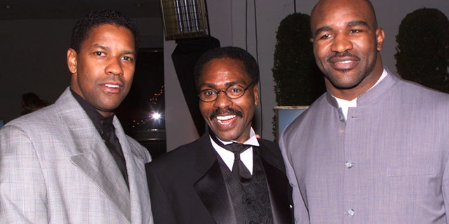 Dec. 14, 1999: Actor Denzel Wahington (L), star of the film "The Hurricane," based on the true story of Rubin "Hurricane" Carter (C), an innocent man who fought for 20 years for justice, poses at the film's premiere party  in Los Angeles with boxing champion Evander Holyfield.