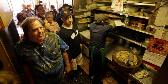 April 20: Sam Begler, left, and other customers wait in the kitchen for a table at the Sam Wo restaurant in Chinatown in San Francisco.