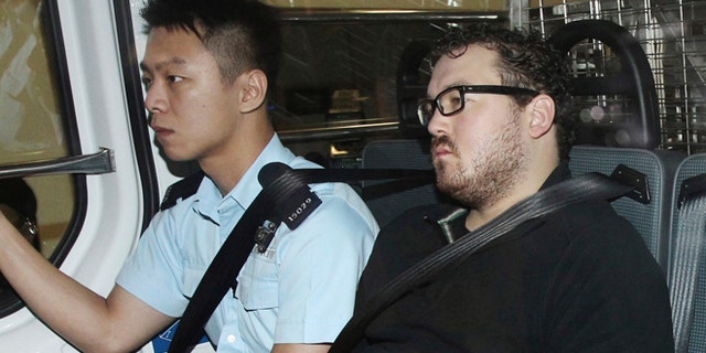 Nov. 3, 2014: Rurik George Caton Jutting, right, is escorted by a police officer in an police van before appearing in a court in Hong Kong.