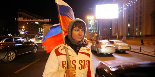 Dec. 2: A young man holding a Russian flag hands out free national flags to motorists in downtown Moscow to celebrate FIFA's selection of Russia as host to the 2018 World Cup.