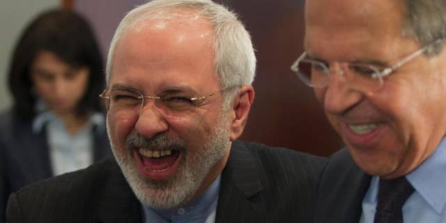Iranian Foreign Minister Mohammad Javad Zarif, left, laughs with his Russian counterpart Sergey Lavrov after the meeting of foreign ministers from Caspian countries, in Moscow, Russia on Tuesday, April 22, 2014. (AP Photo/Ivan Sekretarev)