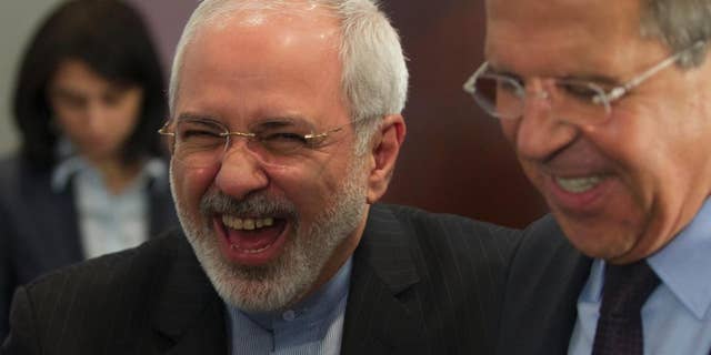 Iranian Foreign Minister Mohammad Javad Zarif, left, laughs with his Russian counterpart Sergey Lavrov after the meeting of foreign ministers from Caspian countries, in Moscow, Russia on Tuesday, April 22, 2014. (AP Photo/Ivan Sekretarev)