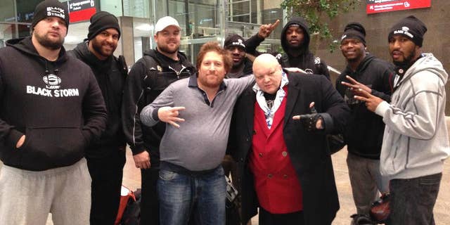 Oct. 14, 2013- FILE photo of Mikhail Zaltsman, (center in grey sweater,) lawyers, and players of the Black Storm American football team in Moscow, after winning the Russian championship in St. Petersburg, Russia. Accused of breaking a window, American businessman Zaltsman now shares a packed jail cell with drug dealers.