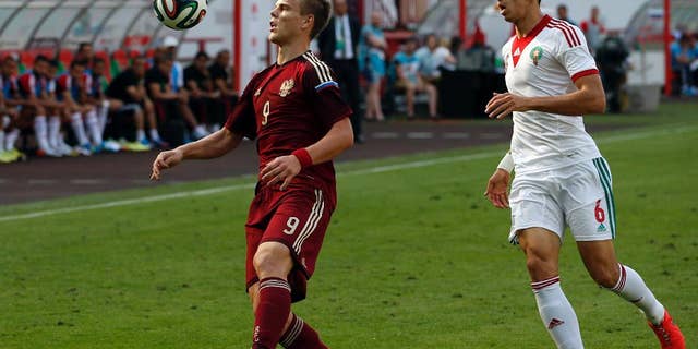 Russia's Alexander Kokorin, left, fights for the ball with Zouhair Feddal, from Morocco during a friendly soccer match in Moscow, Russia, Friday, June 6, 2014. This is the last friendly match before Russia team leaving for Brazil to compete in the World Cup. (AP Photo/Name)