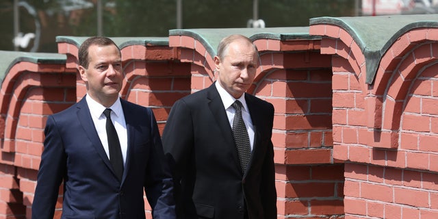 PHOTO: Russian President Vladimir Putin (right) and Prime Minister Dmitry Medvedev walk along the Kremlin wall in June 2015. 