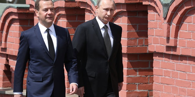 PHOTO: Russian President Vladimir Putin (right) and Prime Minister Dmitry Medvedev walk along the Kremlin wall in June 2015. 