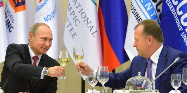 Russian President Vladimir Putin, left, toasts with Marius Vizer, head of IFJ and SportAccord Convention president, during a reception in Russian Black Sea resort of Sochi, Russia, Monday, April 20, 2015. (Alexei Druzhinin/RIA Novosti, Kremlin Pool Photo via AP)