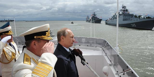 FILE - In this Sunday, July 26, 2015 file pool photo, Russian President Vladimir Putin, centre, reviews a Navy parade in Baltisk, western Russia, during celebration for Russian Navy Day. With dozens of Russian combat jets and helicopter gunships lined up at an air base in Syria, Russian President Vladimir Putin is ready for a big-time show at the United Nations General Assembly. Observers expect the Russian leader to call for stronger U.N.-sanctioned global action against the Islamic State group and possibly announce some military moves in his speech on Monday, Sept. 28, 2015. (Mikhail Klimentyev/RIA-Novosti, Kremlin Pool Photo via AP, file)