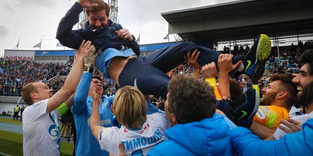 Zenit's players throw Zenit’s head coach Andre Villas-Boas as they celebrate after winning the national soccer Championship after match against Ufa in St.Petersburg, Russia, Sunday, May 17, 2015. (AP Photo/Dmitry Lovetsky)