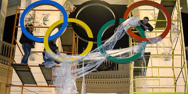 Oct. 28, 2013: Workers are fixing the Olympic emblem at an entrance to the railway station of Russia's Black Sea resort of Sochi, Russia.