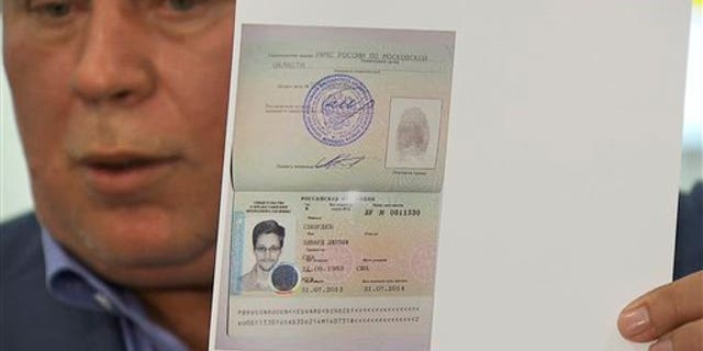 Aug. 1, 2013 - Russian lawyer Anatoly Kucherena showing a temporary document to allow National Security Agency leaker Edward Snowden to cross the border into Russia while speaking to the media after visiting Snowden at Sheremetyevo airport outside Moscow, Snowden has received asylum in Russia for one year and left the transit zone of Moscow's airport, his lawyer said Thursday. (image taken from APTV.)