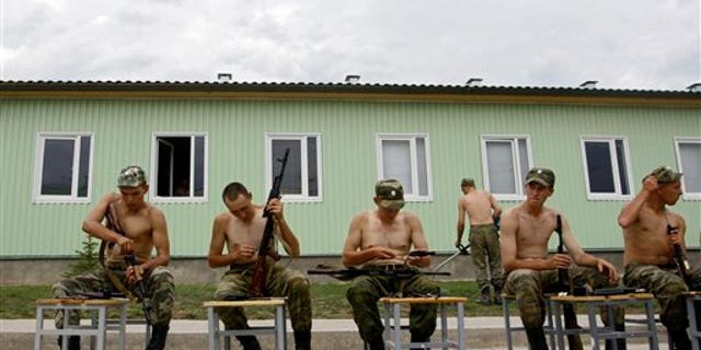 Russian soldiers clean their rifles at the military base in Tskhinvali, regional capital of Georgia's breakaway province of South Ossetia, Friday, Aug. 7, 2009. The separatist Georgian region marks the anniversary of the Georgian invasion that resulted in a brief Russia-Georgia war in Aug. 2008. (AP Photo/Sergey Ponomarev)