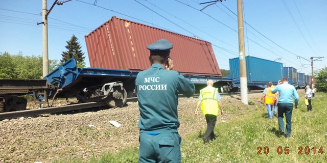 May 20, 2014: A ministry employee uses a mobile phone at the site of train collision near the city of Naro-Fominsk outside Moscow. (AP/ Ministry for Emergency Situations Press Service)