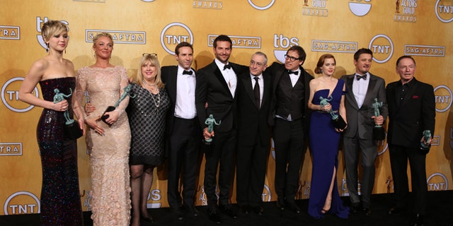 From left, Jennifer Lawrence, Elisabeth Rohm, Colleen Camp, Alessandro Nivola, Bradley Cooper, Robert De Niro, David O. Russell, Amy Adams, Jeremy Renner and Paul Herman pose in the press room with the award for outstanding performance by a cast in a motion picture for âAmerican Hustleâ at the 20th annual Screen Actors Guild Awards at the Shrine Auditorium on Saturday, Jan. 18, 2014, in Los Angeles. (Photo by Matt Sayles/Invision/AP)