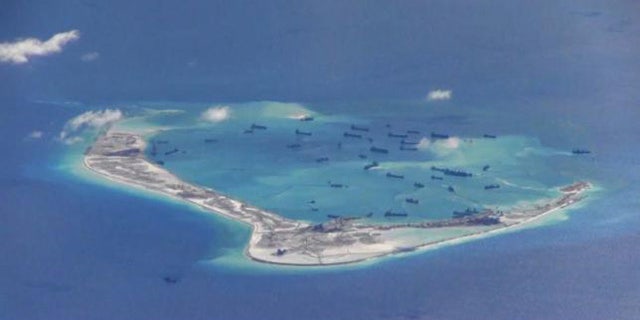 May 21, 2015: Chinese dredging vessels are purportedly seen in the waters around Mischief Reef in the disputed Spratly Islands in the South China Sea in this still image from video taken by a P-8A Poseidon surveillance aircraft. (U.S. Navy)