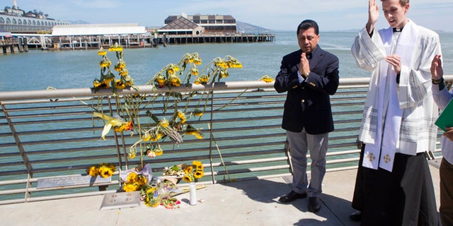 Father Cameron Faller and Julio Escobar conduct a vigil for Kathryn Steinle on Pier 14 in San Francisco, July 6, 2015.