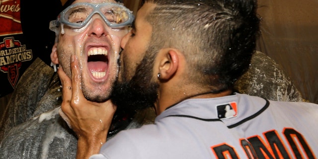 Sergio Romo kisses Marco Scutaro as they are sprayed with champagne in the locker room as San Francisco Giants celebrate after the Giants defeated the Detroit Tigers, 4-3, in Game 4 of baseball's World Series Sunday, Oct. 28, 2012, in Detroit. The Giants won the World Series 4-0. (AP Photo/David J. Phillip)