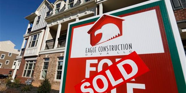 FILE - In this Jan. 8, 2015 photo, a sign with a sold sticker is posted in front of a row of new townhomes in Richmond, Va. Mortgage giant Freddie Mac on Thursday, March 26, 2015 said the national average for a 30-year fixed-rate mortgage declined to 3.69 percent from 3.78 percent a week earlier. (AP Photo/Steve Helber, File)