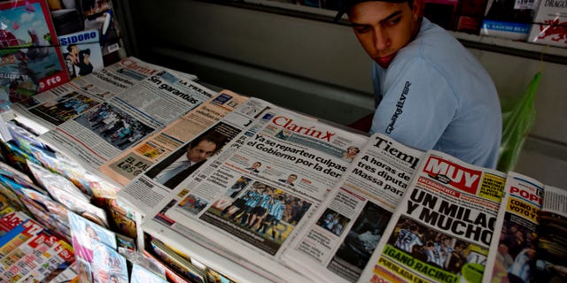 A vendor sits in his newspaper stand in Buenos Aires, Argentina, Tuesday, Oct. 29, 2013.