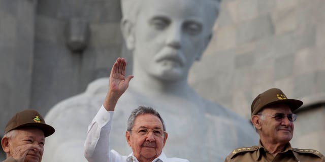 El presidente cubano Raúl Castro, al centro, saluda a las personas que participan en la marcha por el Día del Trabajo, en la Plaza de la Revolución, en La Habana, el 1 de mayo de 2013. Washington no tiene planes de quitar a Cuba de la lista de gobiernos que apoyan al terrorismo y que también incluye a Irán, Siria y Sudán, dijo el miércoles un portavoz del Departamento de Estado. (Foto AP/Ramon Espinosa)
