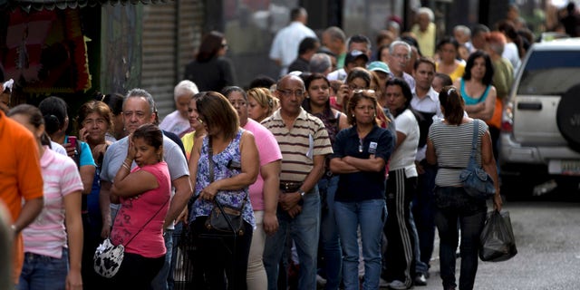Shoppers wait in line outside of a supermarket on March 2, 2014 in Caracas, Venezuela.