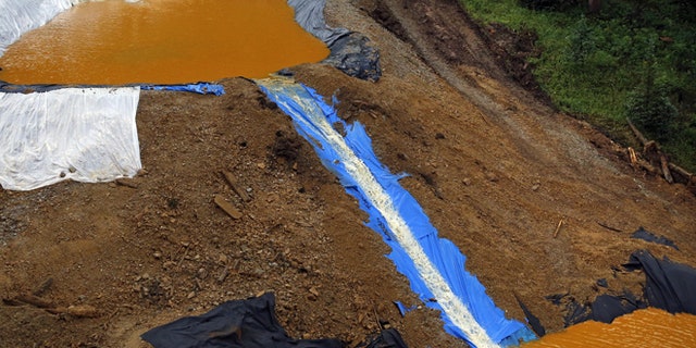 Water flows through a series of retention ponds built to contain and filter out heavy metals and chemicals from the Gold King mine wastewater accident, in the spillway about 1/4 mile downstream from the mine, outside Silverton, Colo., Wednesday, Aug. 12, 2015. The Environmental Protection Agency has taken full responsibility for the mine waste spoiling rivers downstream from Silverton, but people who live near the idled and leaking Gold King mine say local authorities and mining companies spent decades spurning federal cleanup help. (AP Photo/Brennan Linsley)