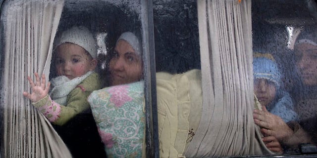 Dec. 20, 2012: Syrian refugees, who fled their home in Idlib due to a government airstrike, look out of a vehicle window just after crossing the border from Syria to Turkey.